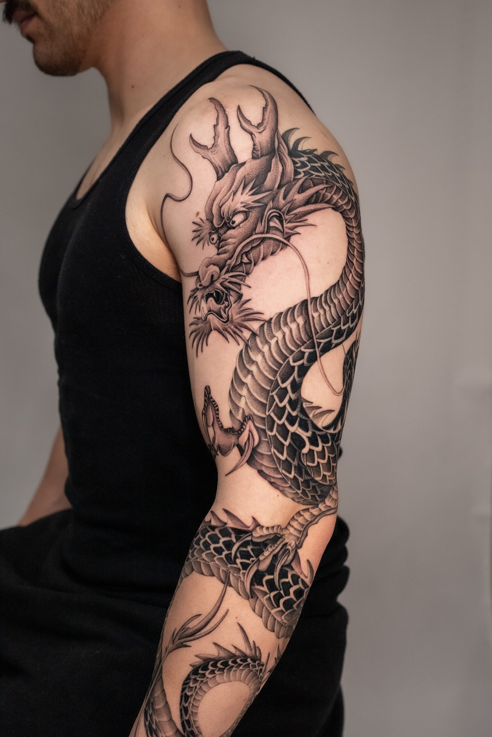 Black and grey dragon sleeve tattoo by Kel Otero